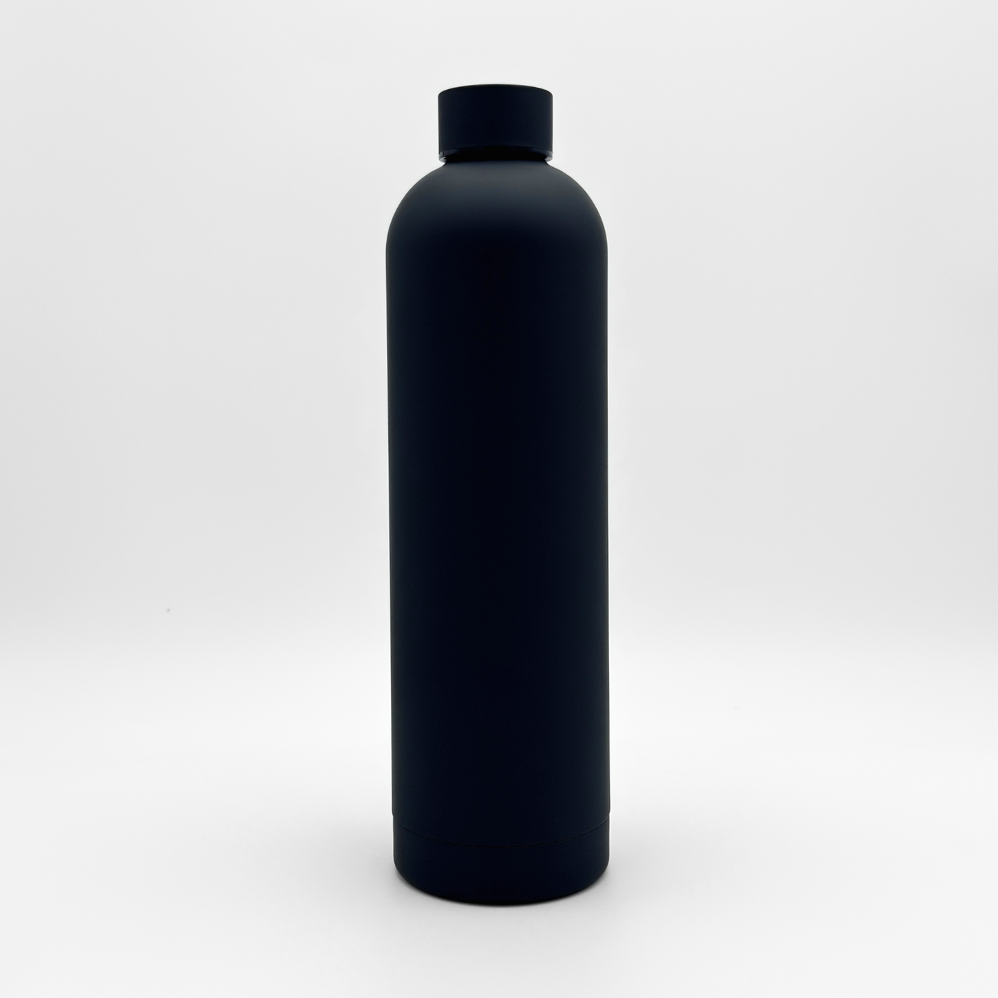 The Core Series Plus | Onyx Black bottle, a black cylindrical insulated flask with a matching cap, is centered against a plain white background. Featuring a smooth matte finish free of visible labels or markings, this bottle’s double-walled stainless steel construction ensures optimal temperature retention. Its sleek silhouette suggests a leakproof lid designed for both convenience and reliability.