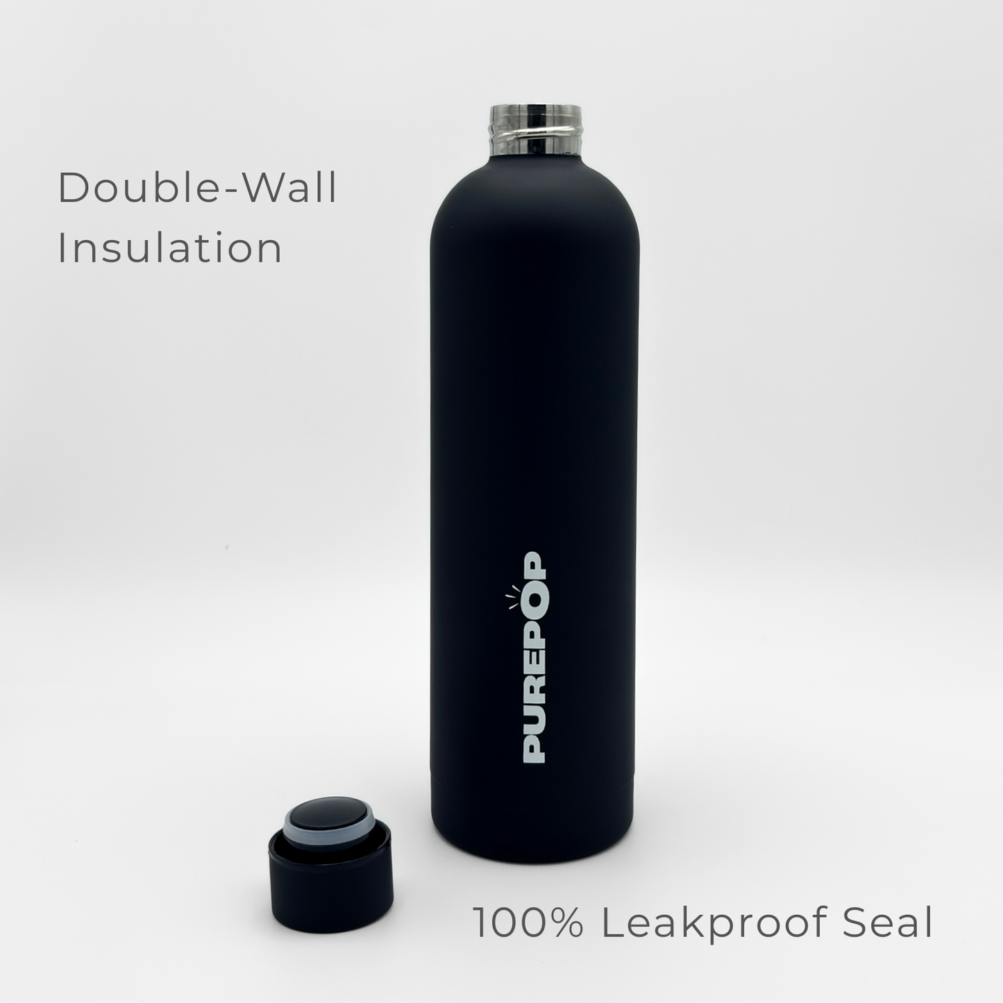 A Core Series Plus | Onyx Black water bottle stands upright with its lid off, featuring the PUREPOP label. On the left, text reads “Double-Wall Insulation,” emphasizing its durable double-walled stainless steel construction, while on the right, it says “100% Leakproof Seal.”.