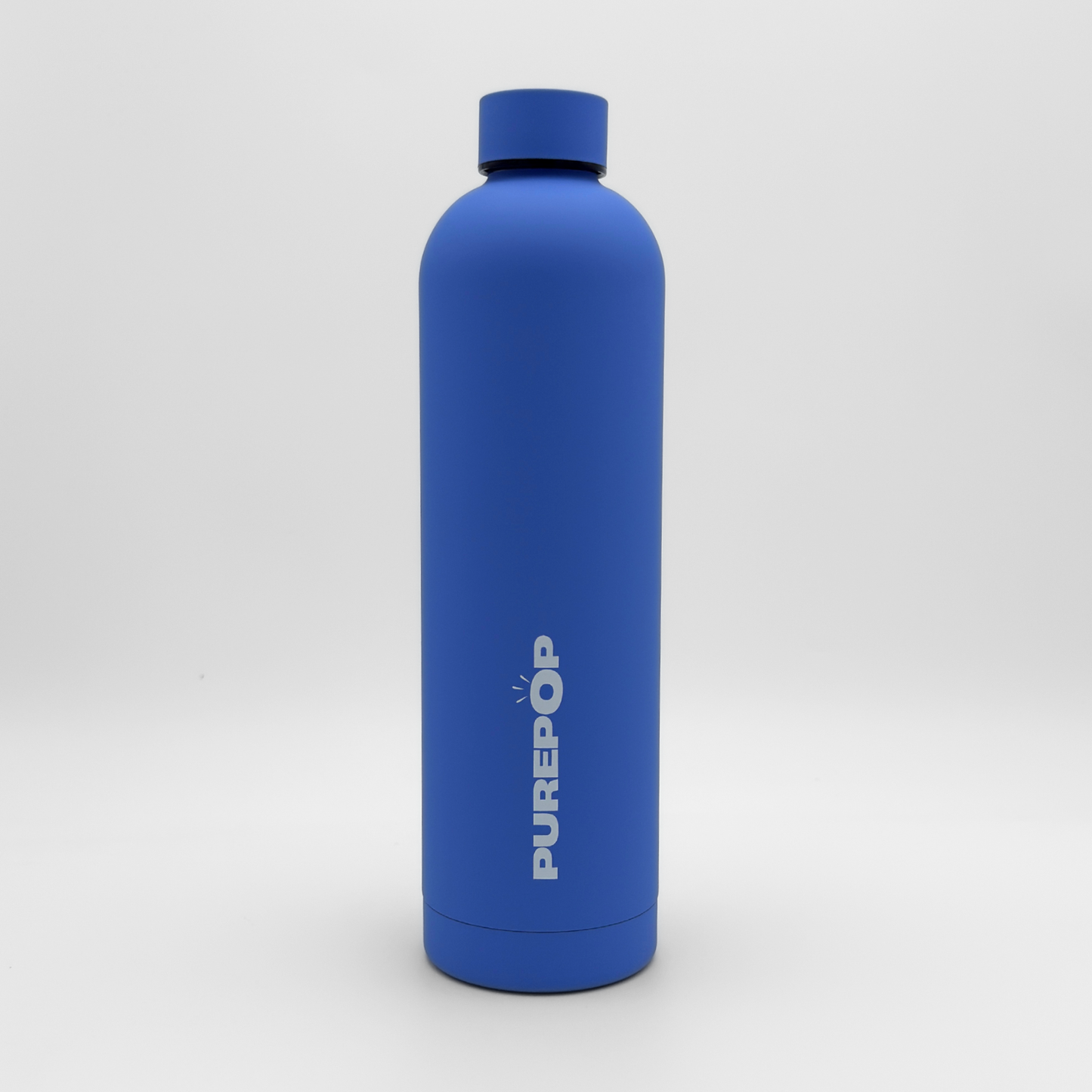 An Ultra Marine blue Core Series Plus reusable water bottle, featuring the PUREPOP logo printed vertically in white, stands upright against a plain white background. This insulated flask boasts a double-walled stainless steel construction to keep beverages cold for hours and is fully leakproof for worry-free hydration on the go.
