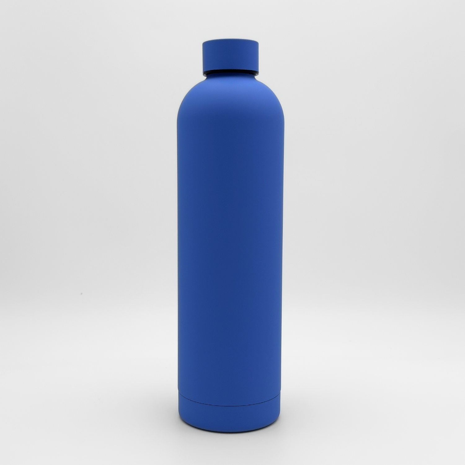 The Core Series Plus | Ultra Marine is a plain blue reusable water bottle with a screw-on cap, standing upright against a white background. This insulated flask is designed to keep your drinks at the perfect temperature.