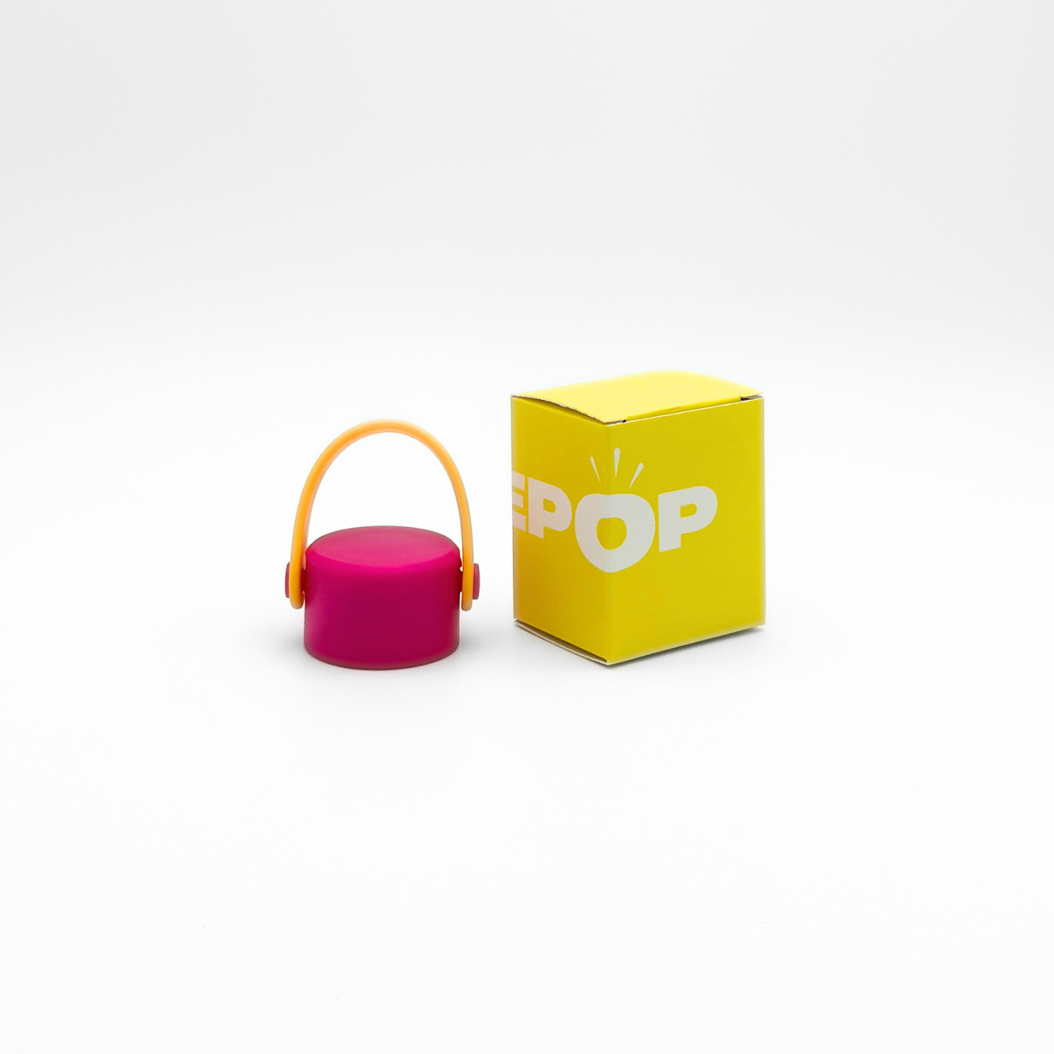 A compact, round Core Series flask in magenta with a gold carry lid and a leakproof seal is placed next to a yellow box labeled POP on a plain white background.