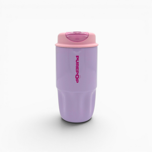 A Sip Series | Soft Lilac reusable coffee cup, featuring a lavender body with a pink lid and the word PURADO printed vertically in pink on the side, shown against a white background—perfect as a stylish, leakproof travel mug for your daily adventures.