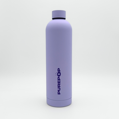 A tall, matte pastel lilac leakproof water bottle from the Core Series Plus collection stands upright on a white background. The double-walled stainless steel bottle features a matching lilac cap and has "PUREPOP" printed vertically in bold blue letters on the front.