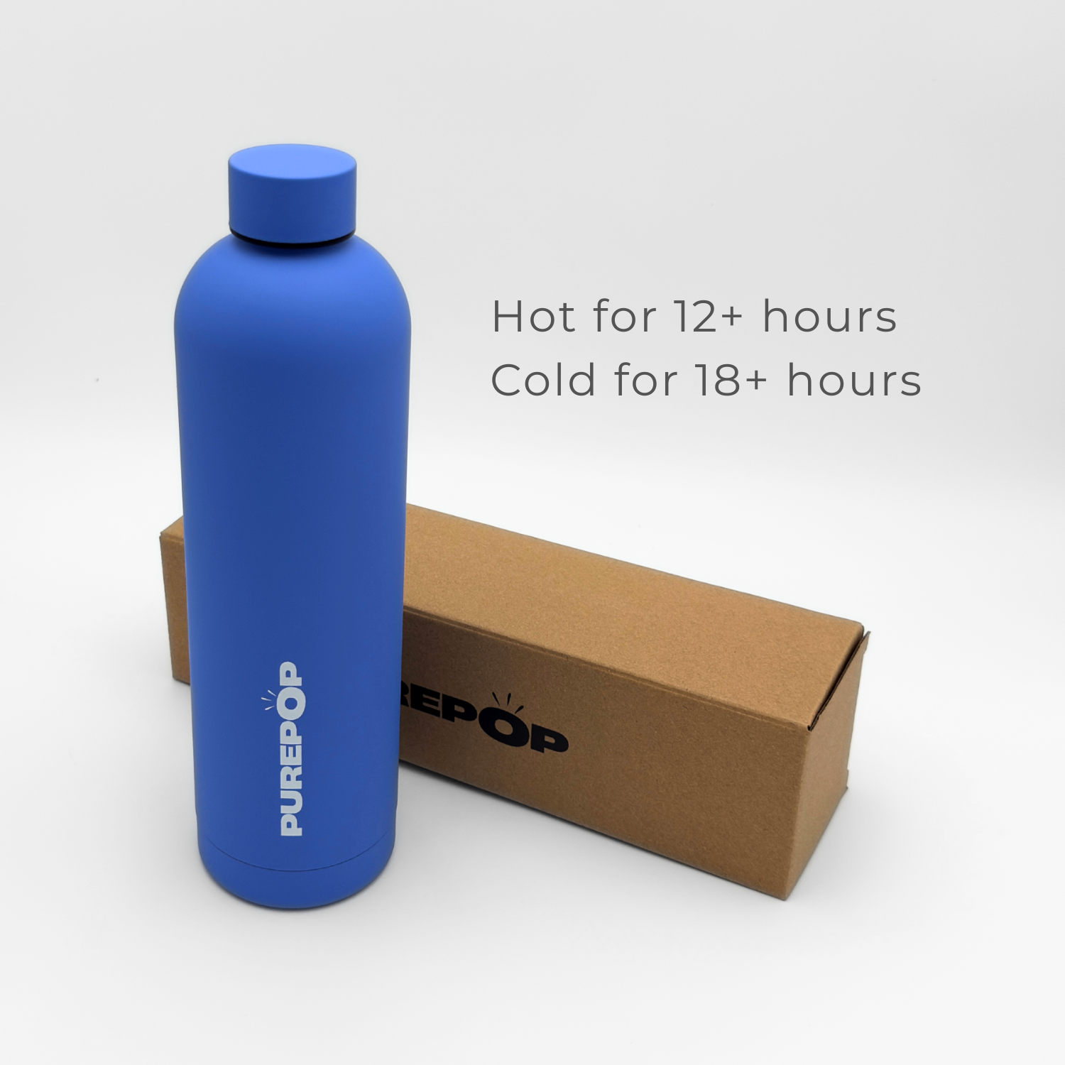 A Core Series Plus | Ultra Marine insulated flask stands next to a brown box. Text reads: Hot for 12+ hours, Cold for 18+ hours. This double-walled stainless steel, leakproof flask is set against a plain white background.