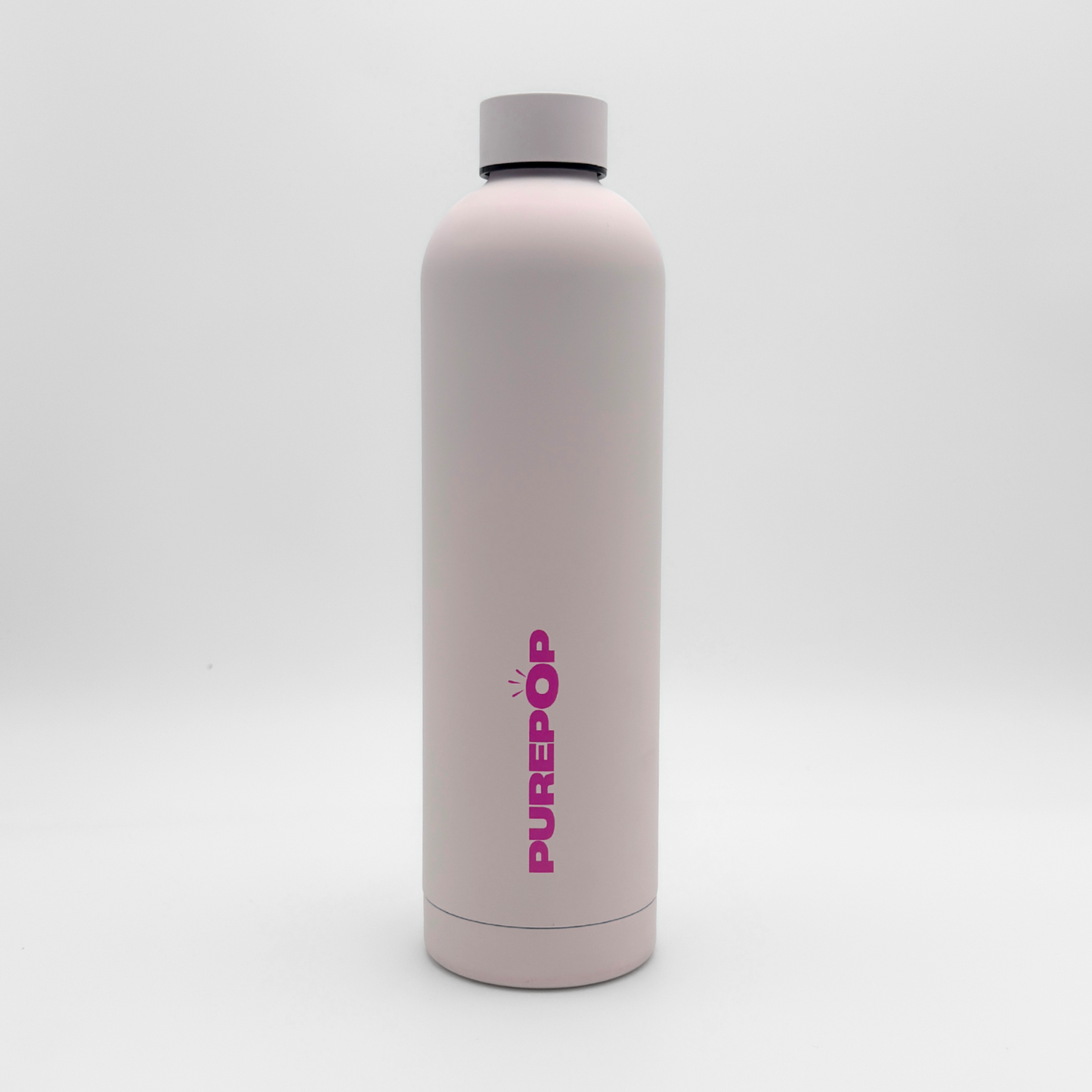 A tall Core Series Plus | Cloud Pink water bottle stands upright on a plain white background, featuring the PUREPOP brand name in bold pink letters. Crafted from double-walled stainless steel for superior insulation, this flask keeps drinks hot or cold for hours and boasts a leakproof design for worry-free carrying.