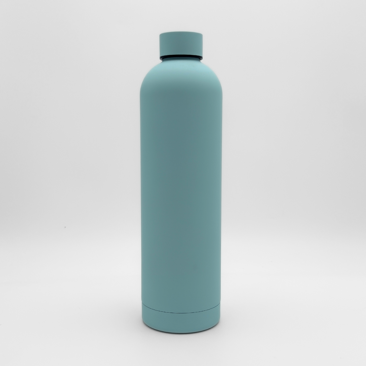 The Core Series Plus | Ice Blue, a matte light blue insulated flask with a screw-on lid, is standing upright against a white background.