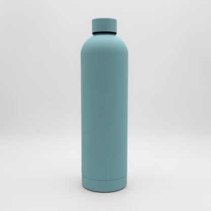 The Core Series Plus | Ice Blue, a matte light blue insulated flask with a screw-on lid, is standing upright against a white background.