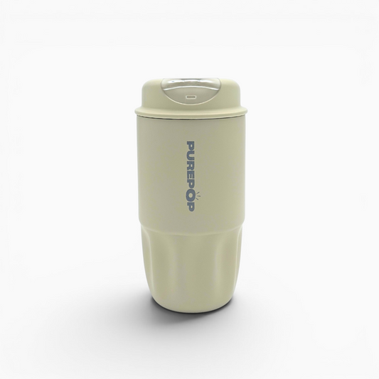 A beige, cylindrical reusable coffee cup from the Sip Series in Ivory, featuring a clear lid and vertically labeled PUREPOP in blue text, stands upright on a white background.