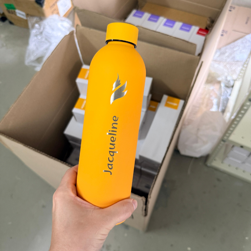Orange PurePop flask engraved with Jacqueline and a silver flame logo.