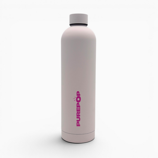 Introducing the Core Series Plus | Cloud Pink: a reusable, leakproof water bottle in light pink with a gray cap, standing upright. "PUREPOP" is printed vertically in bold pink letters on the front. Crafted with stainless steel thermal insulation, this insulated flask keeps your beverages at the ideal temperature. The product is set against a plain white background.